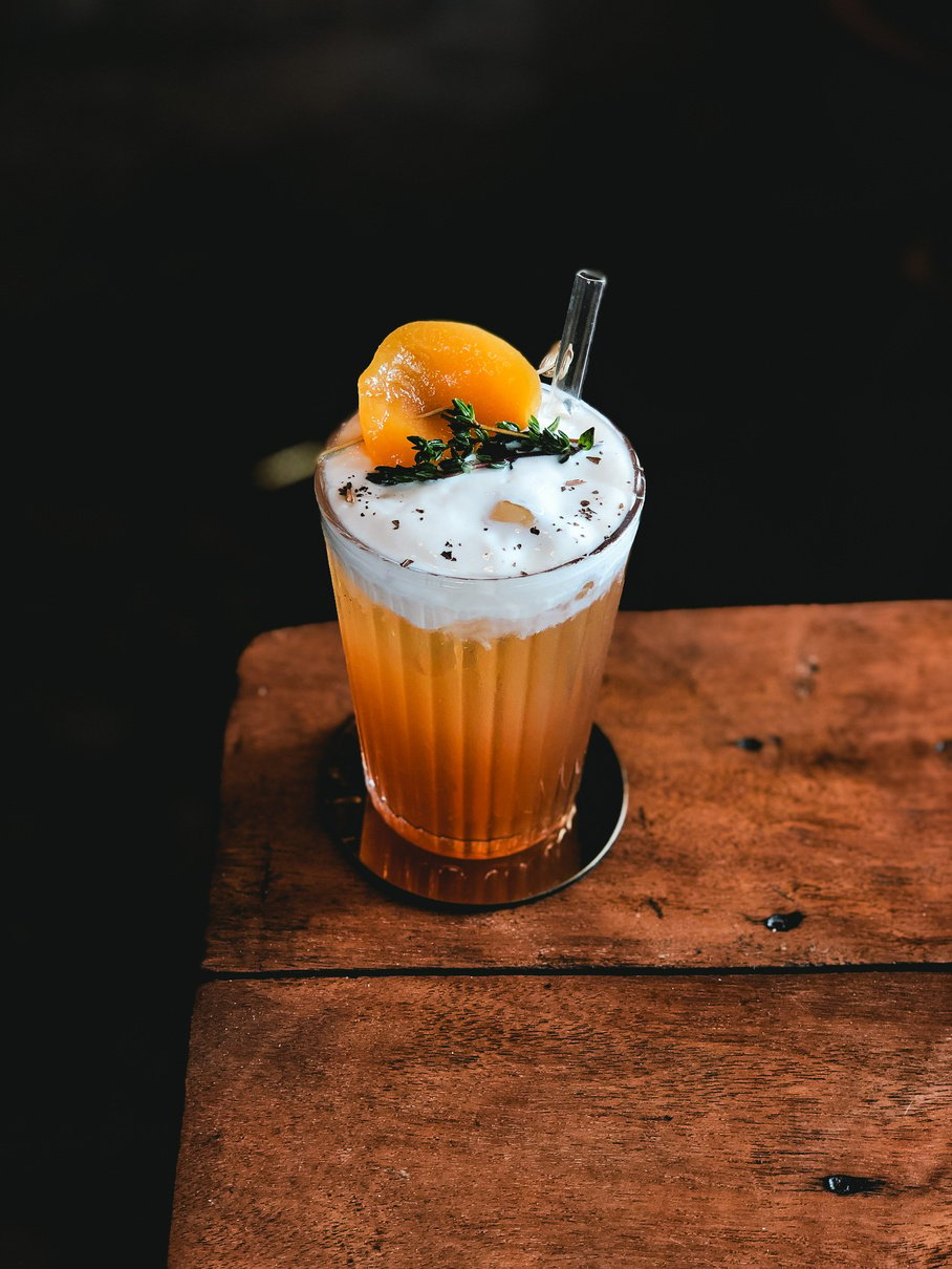 Cold cocktail with straw in glassware