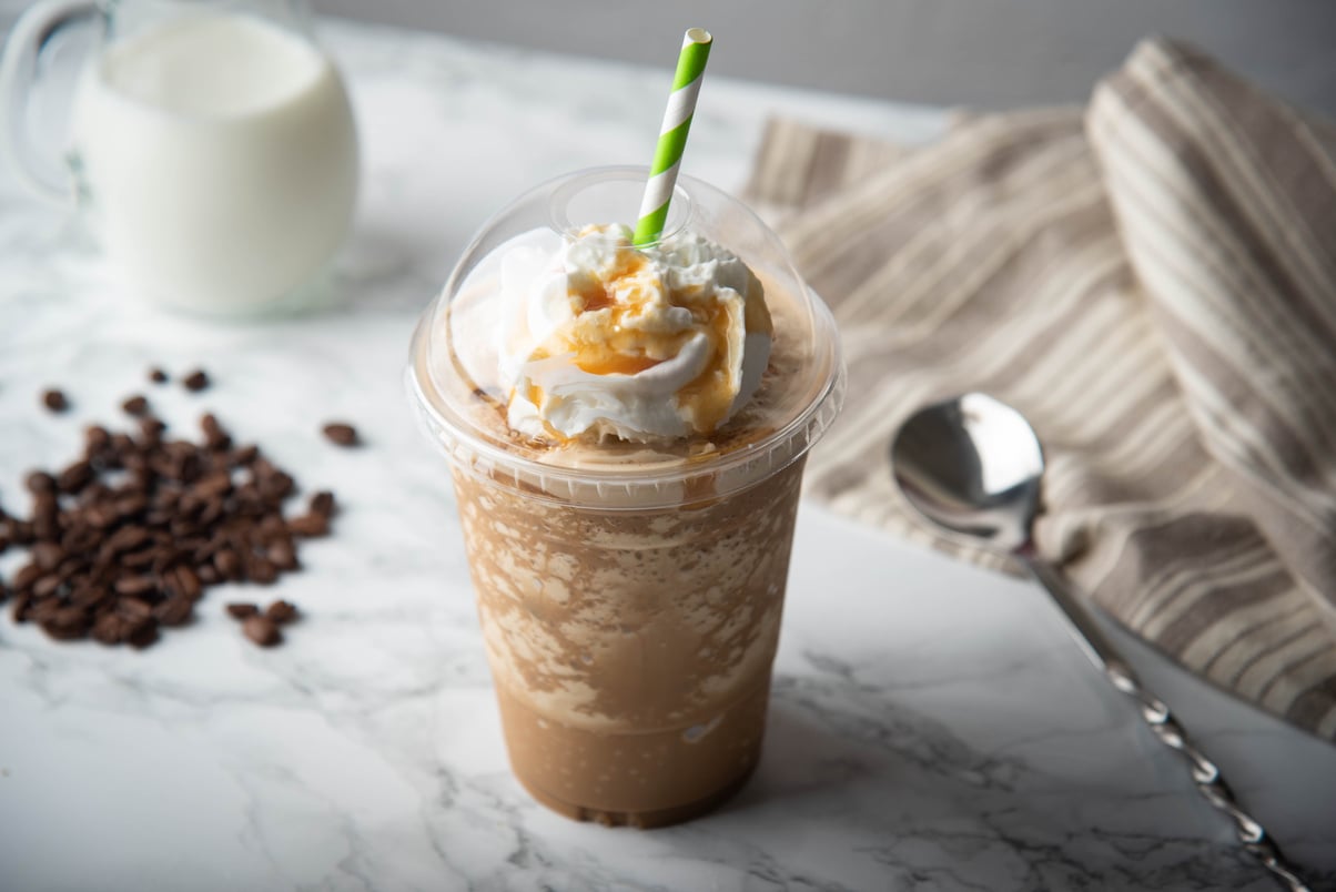 caramel frappuccino with whipped cream on marble table