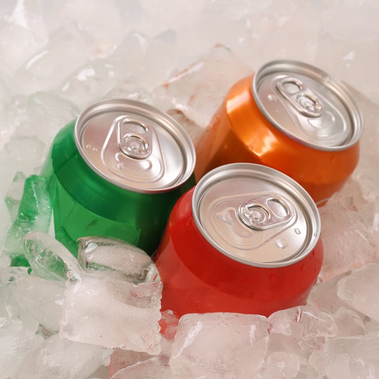 Cola and lemonade beverages in cans on ice